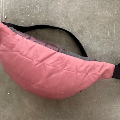 Pink quilted bag on a concrete floor